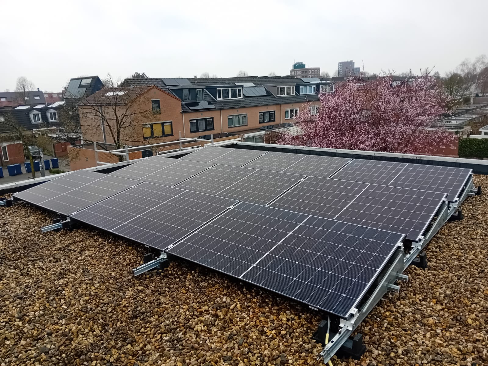 Deze installatie toont een set zonnepanelen op een dak, geïnstalleerd op een grindbed.
