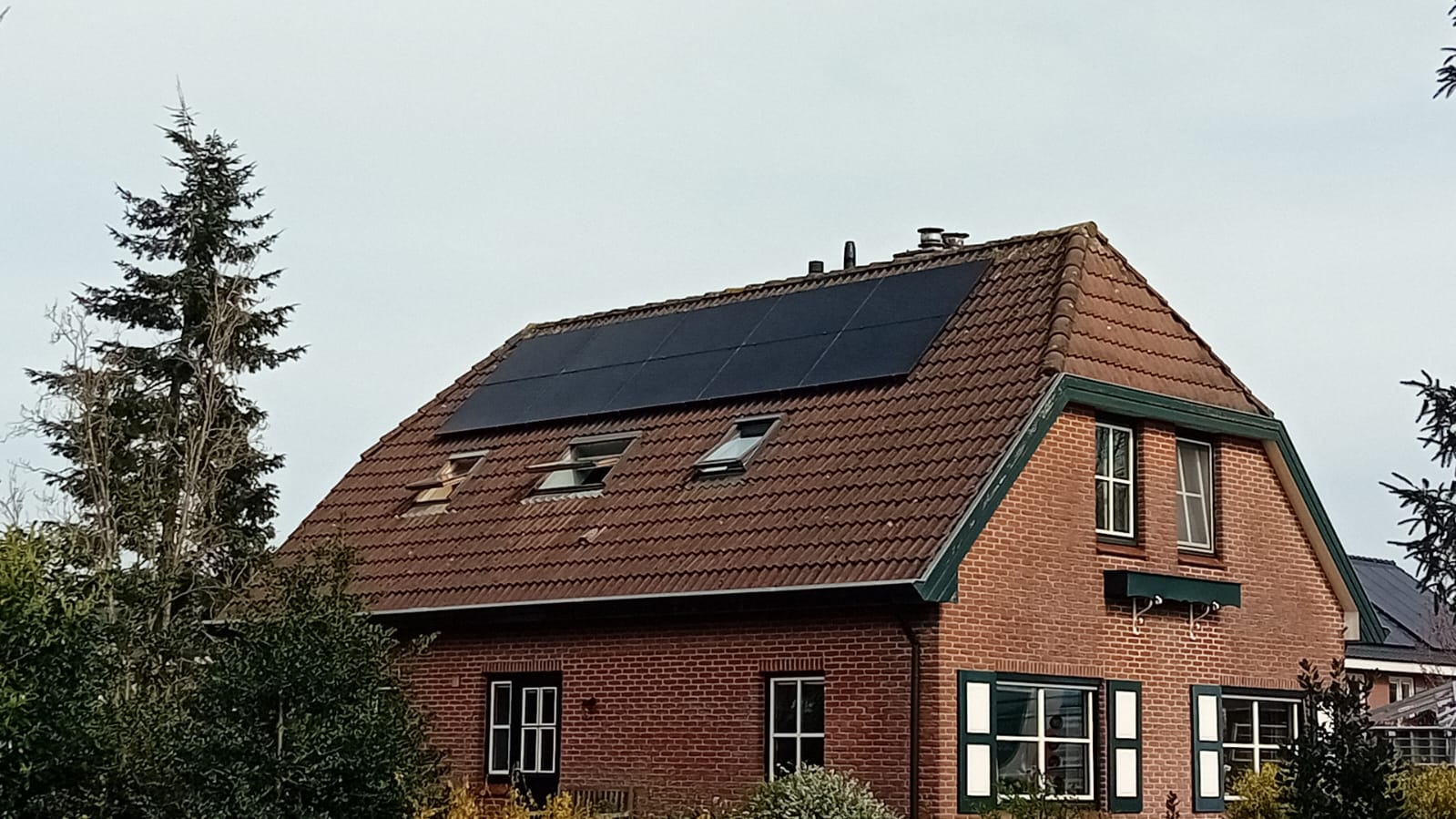 De installatie toont een huis met zonnepanelen op het schuine dak. De panelen zijn goed zichtbaar en zijn gericht op het zuiden voor optimale zoninname.