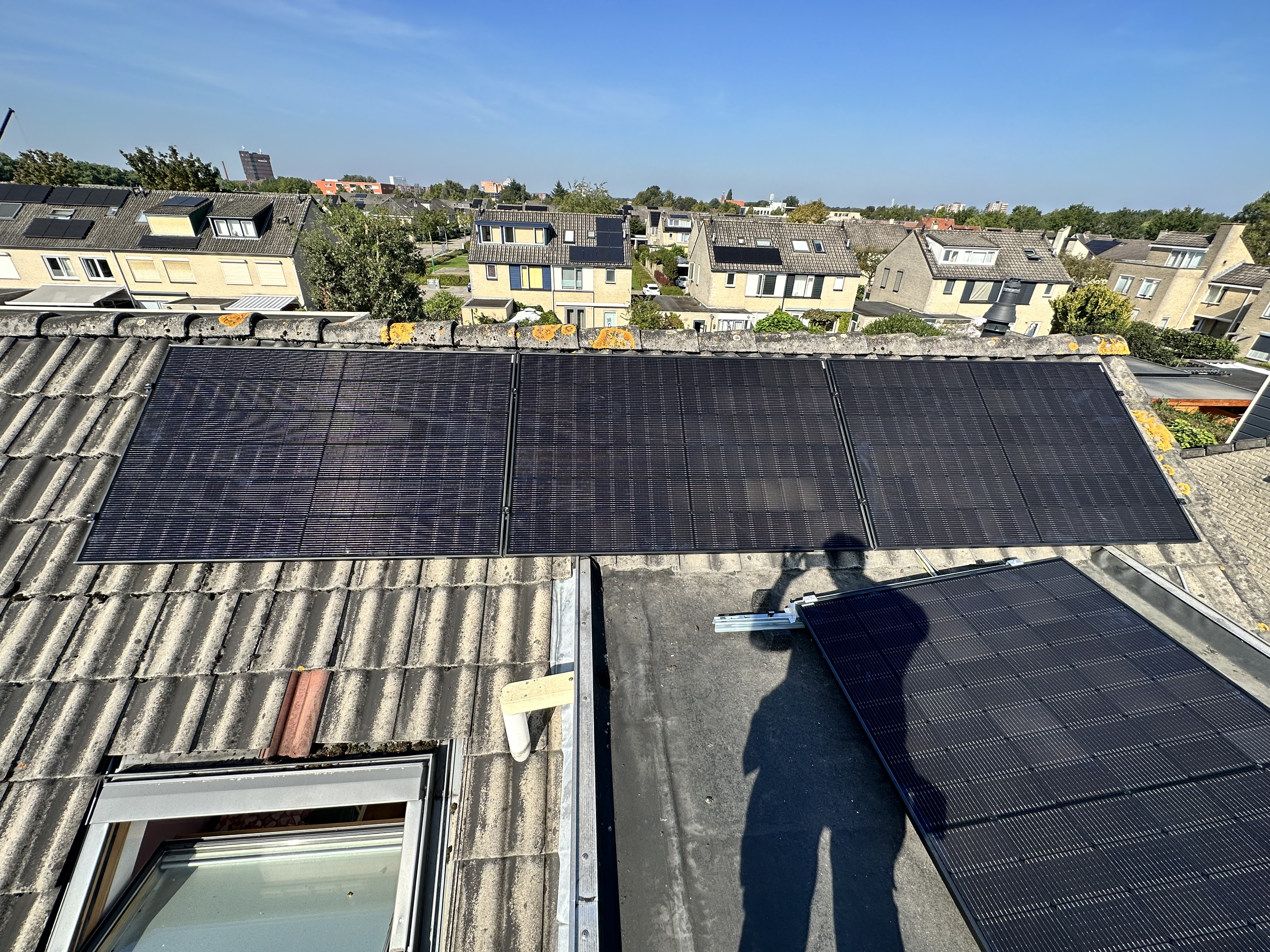 De afbeelding toont een zonnepaneleninstallatie op een dak met meerdere zonnepanelen, gericht op het opwekken van zonne-energie.
