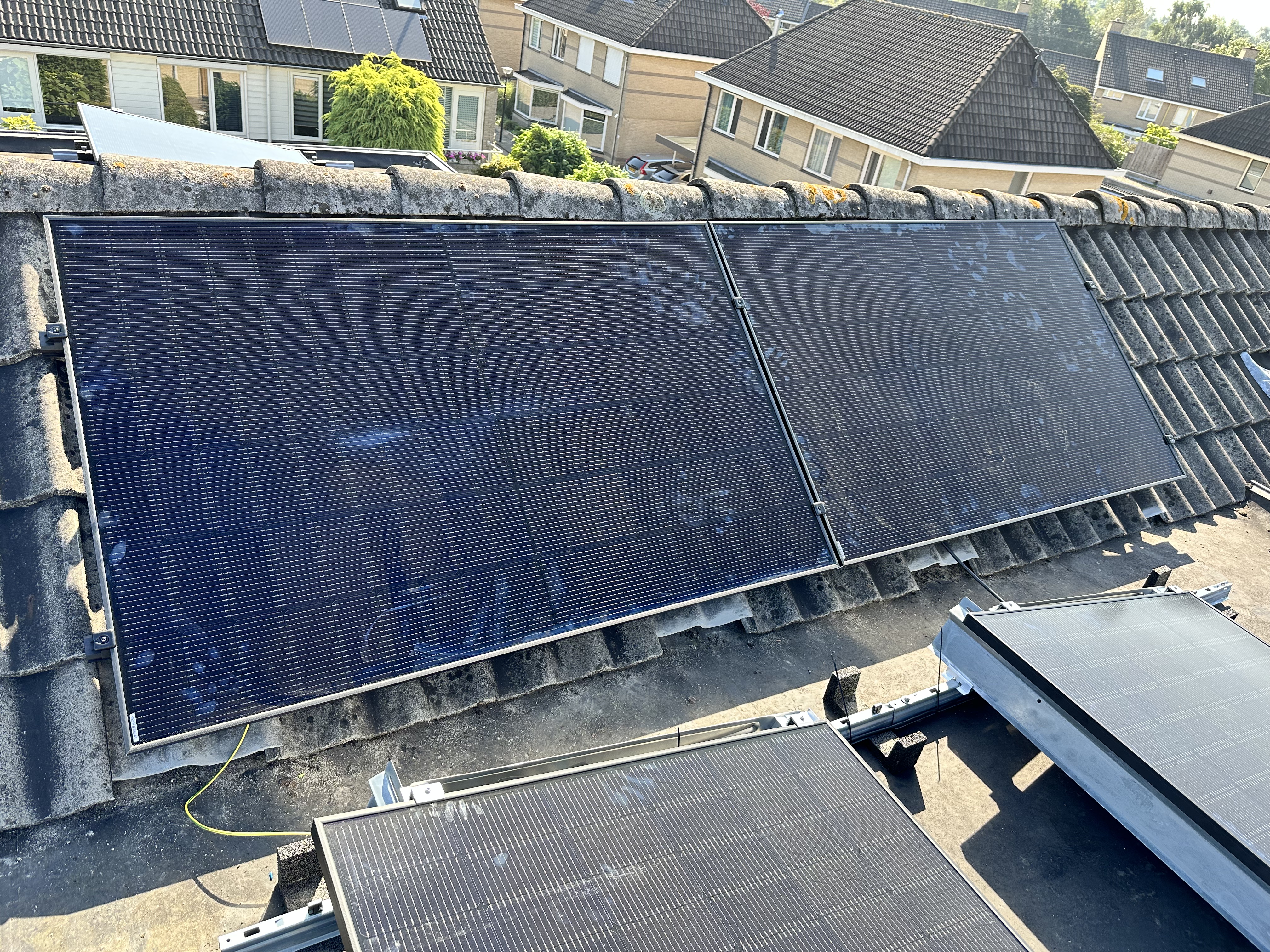 Deze afbeelding toont zonnepanelen op het dak van een woning, gericht op het genereren van zonne-energie.