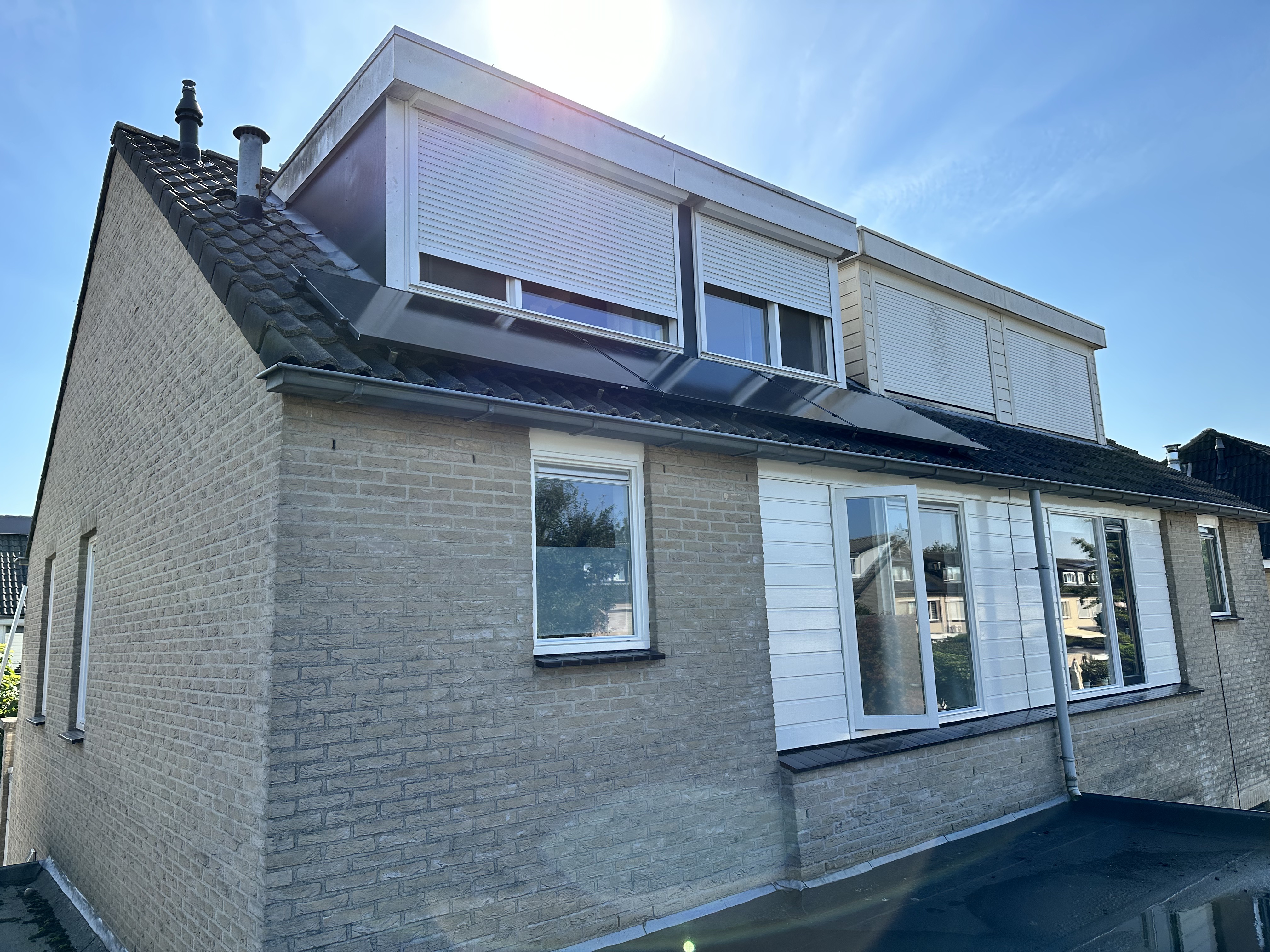 Een woning met zonnepanelen op het schuine dak, gericht op een duurzame energieoplossing.