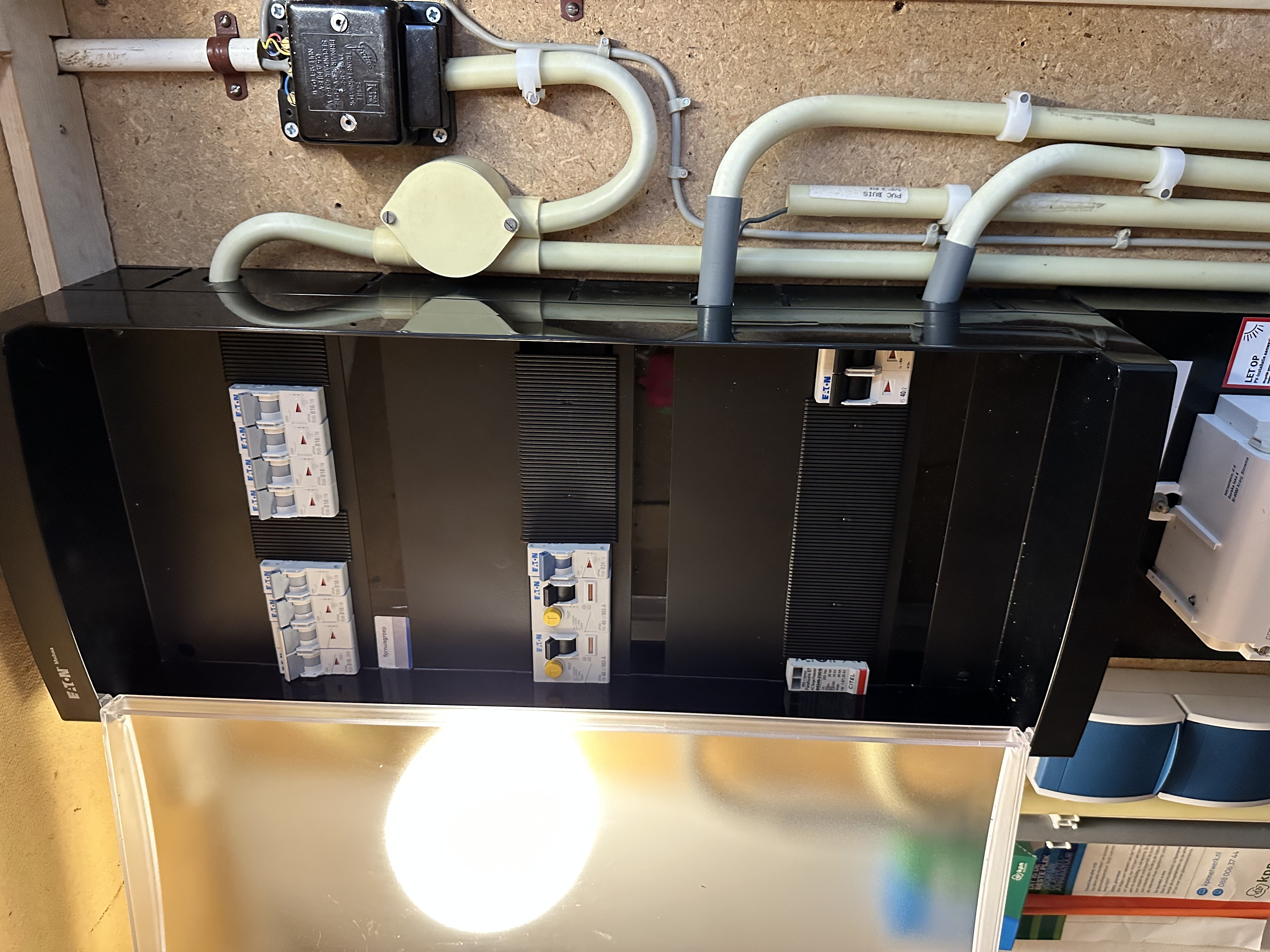 De afbeelding toont een meterkast met verschillende schakelaars en bedrading, essentieel voor de aansluiting van zonne-energie systemen.