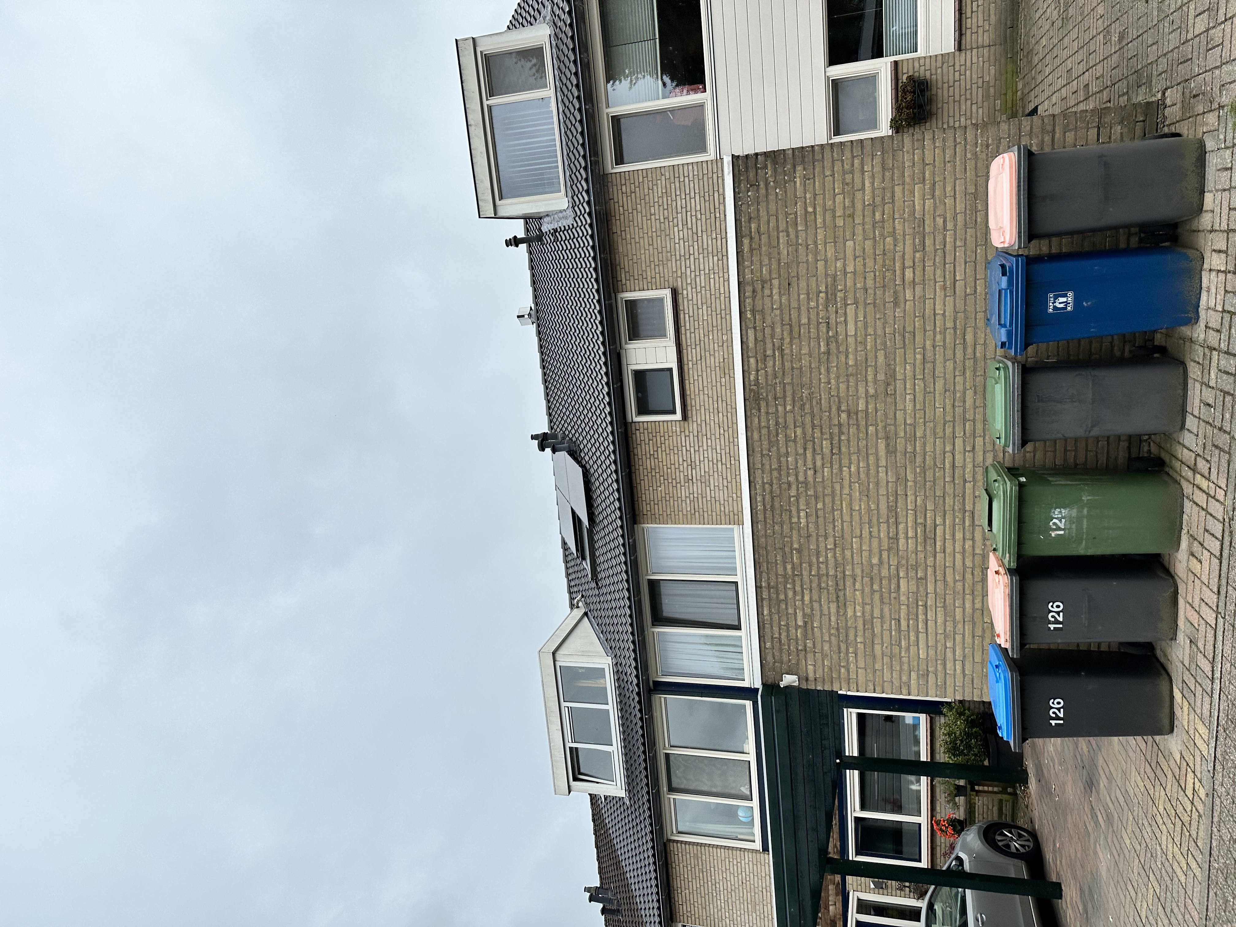De foto toont een huis met zonnepanelen op het dak, wat wijst op een installatie voor hernieuwbare energie.