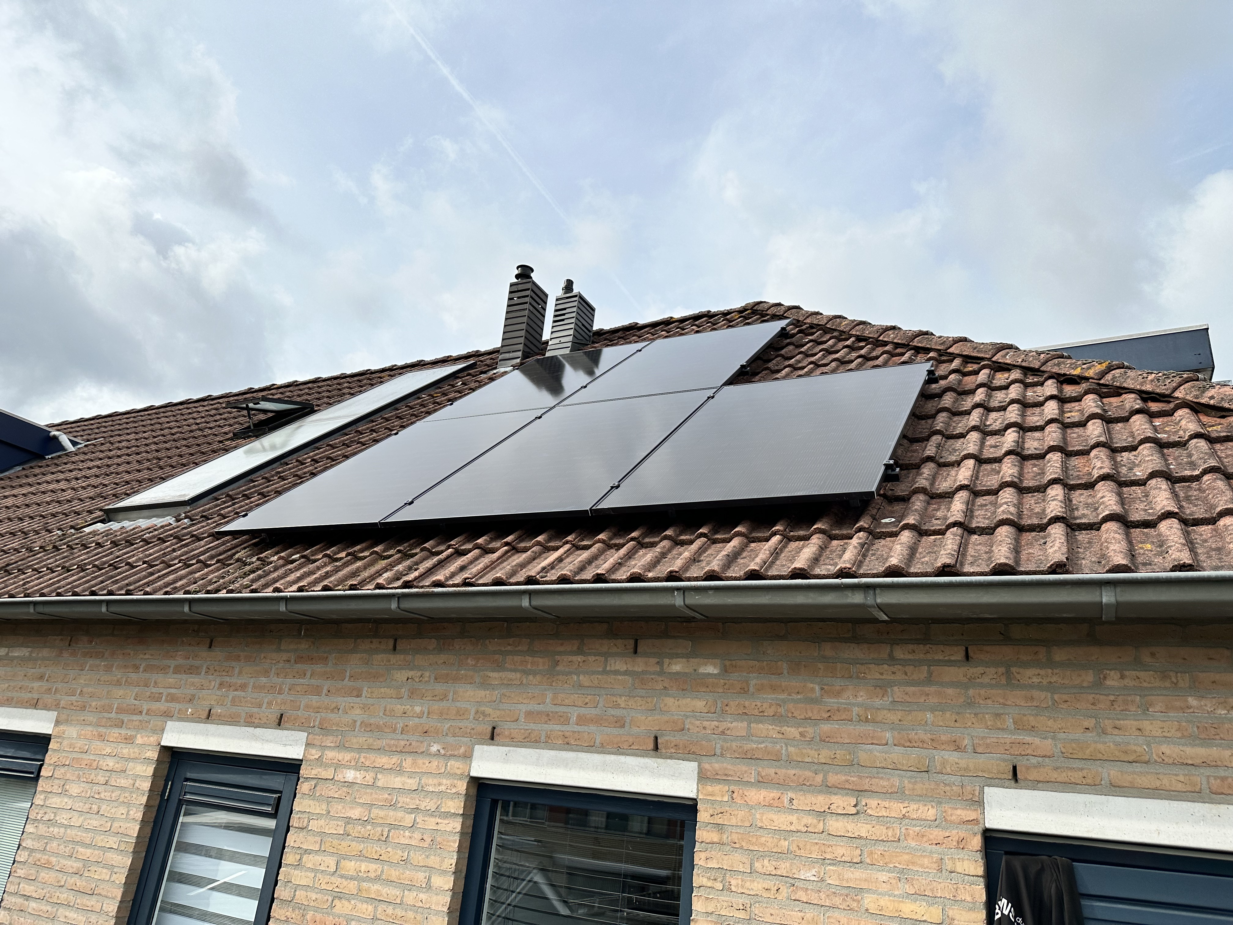 Een installatie van zonnepanelen op een hellend dak, perfect gepositioneerd voor optimale zonlichtopvang.