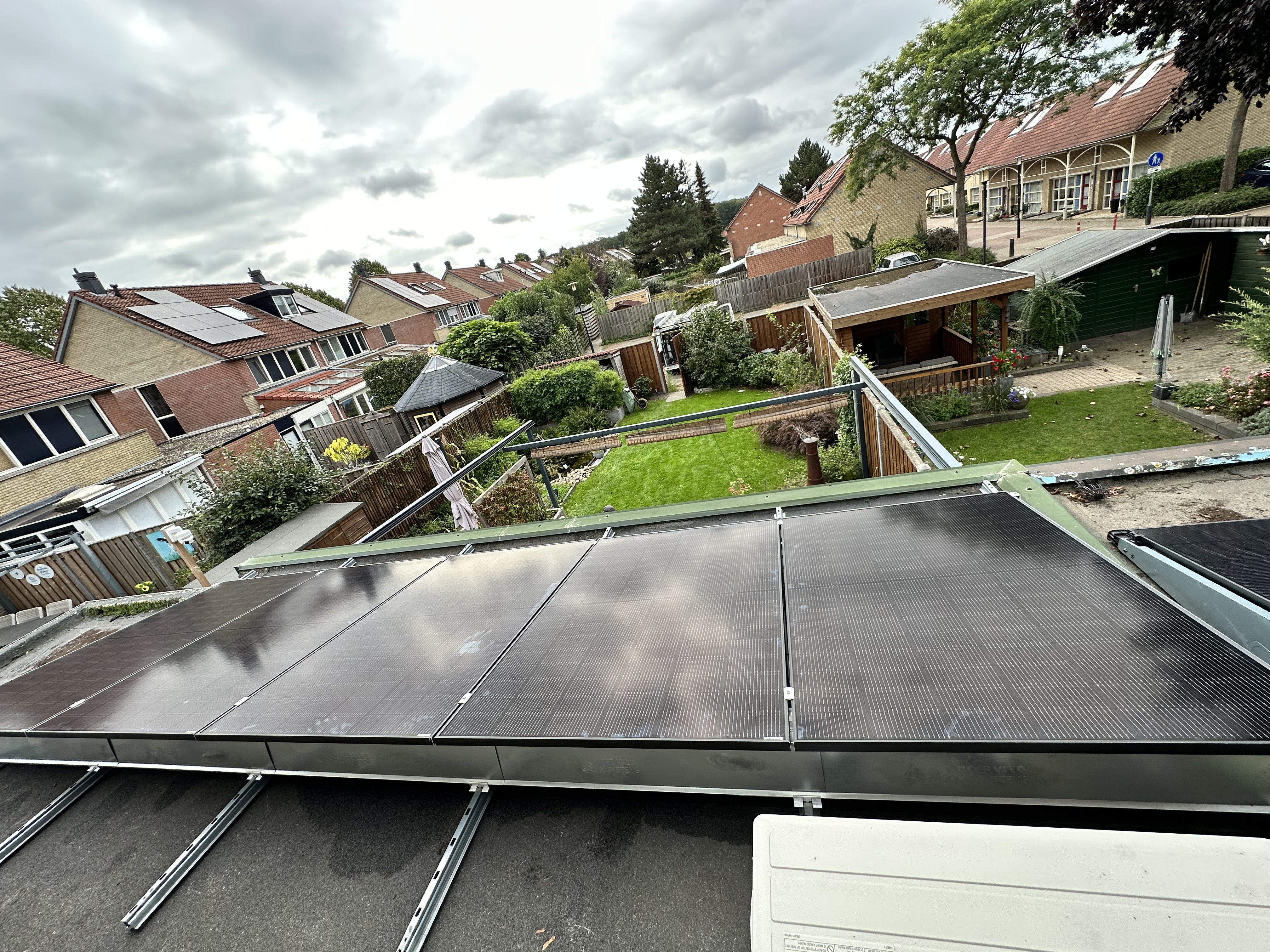 Een installatie van zonnepanelen op een schuine dak met meerdere panelen zichtbaar.