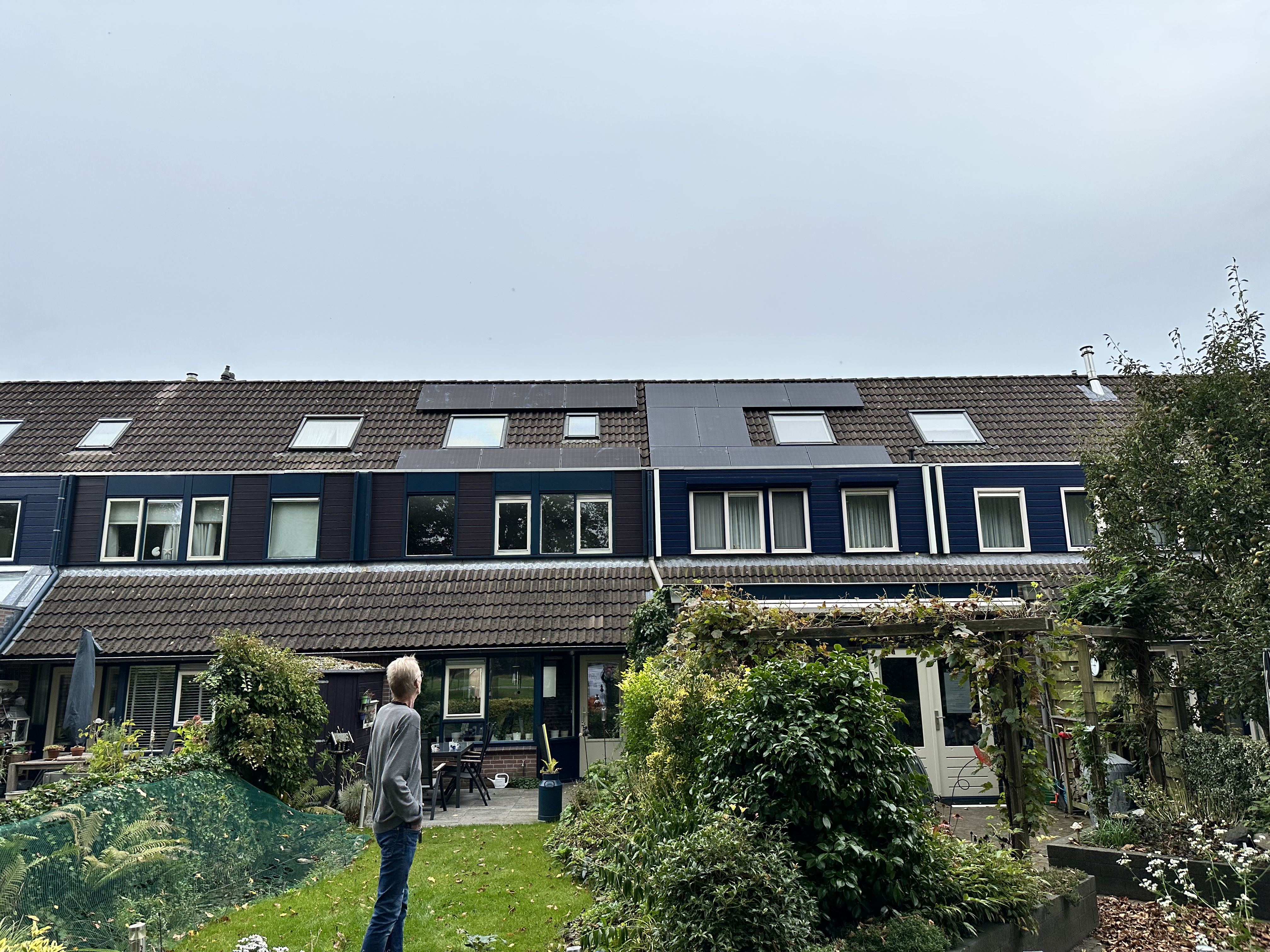 De afbeelding toont een woning met zonnepanelen op het dak, geïnstalleerd voor hernieuwbare energieoplossingen.