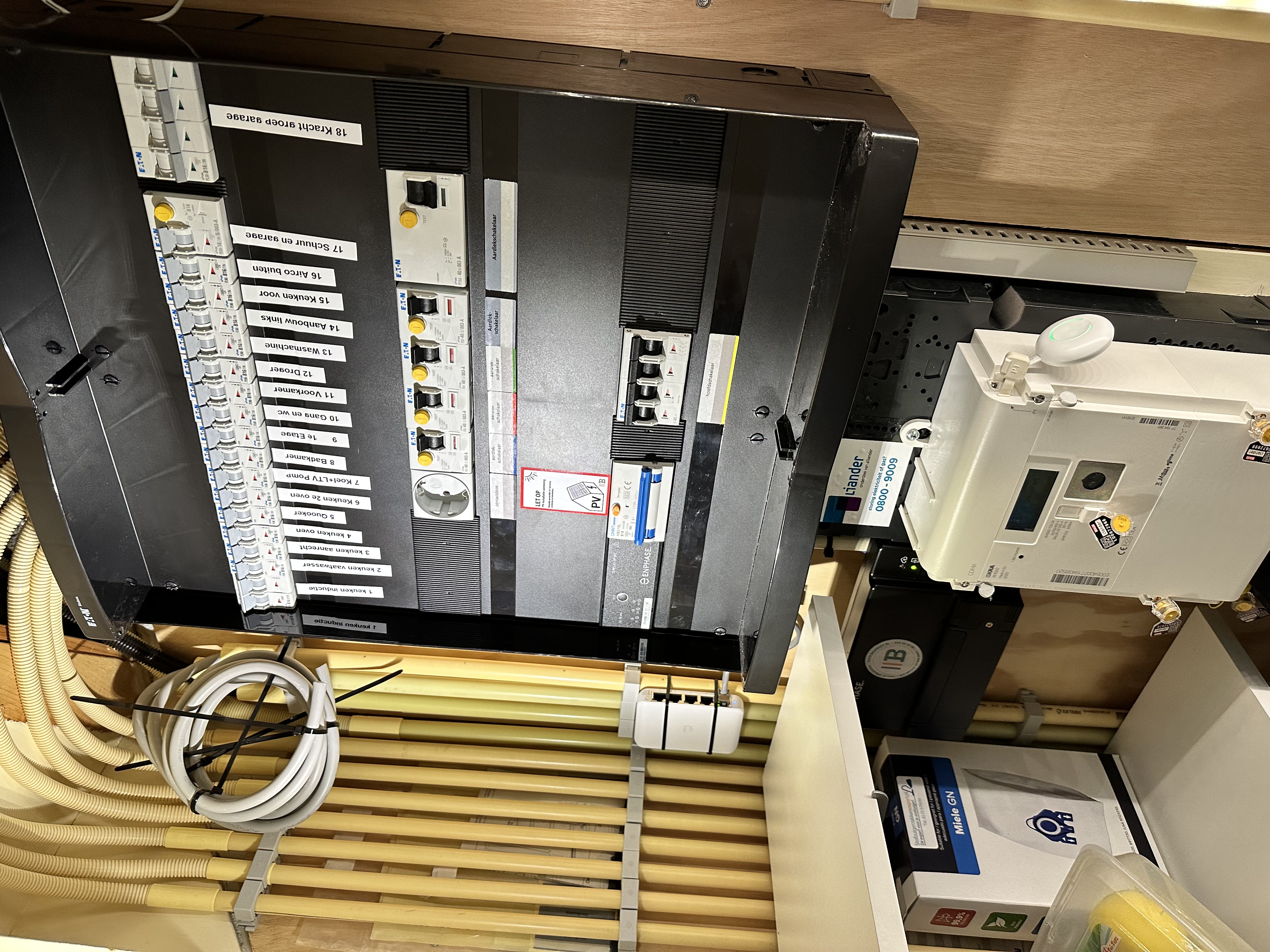De foto toont een meterkast met bedradings voor zonnepanelen en gerelateerde apparatuur.