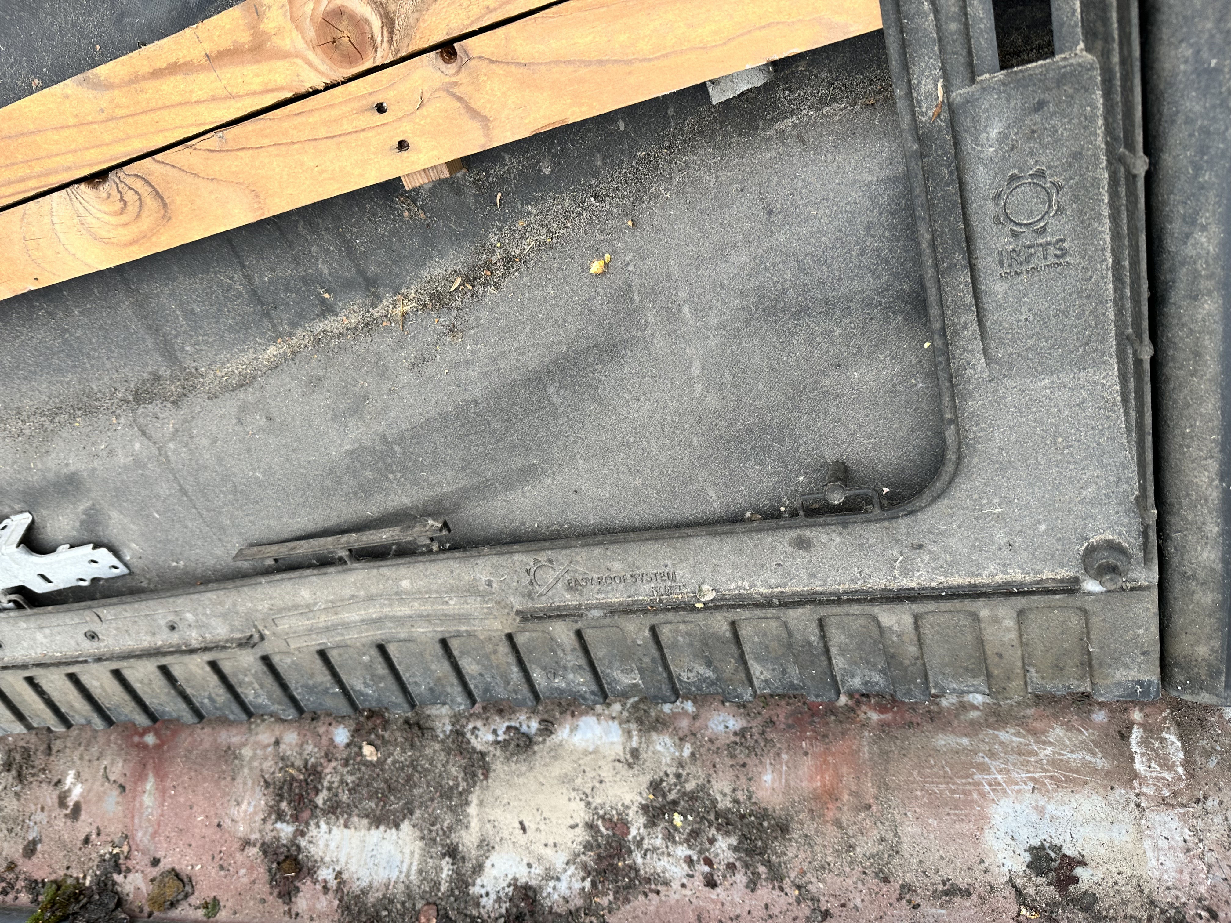 De afbeelding toont een deel van een laadpaalinstallatie, zichtbaar in een ruwe en ongeregelde omgeving.