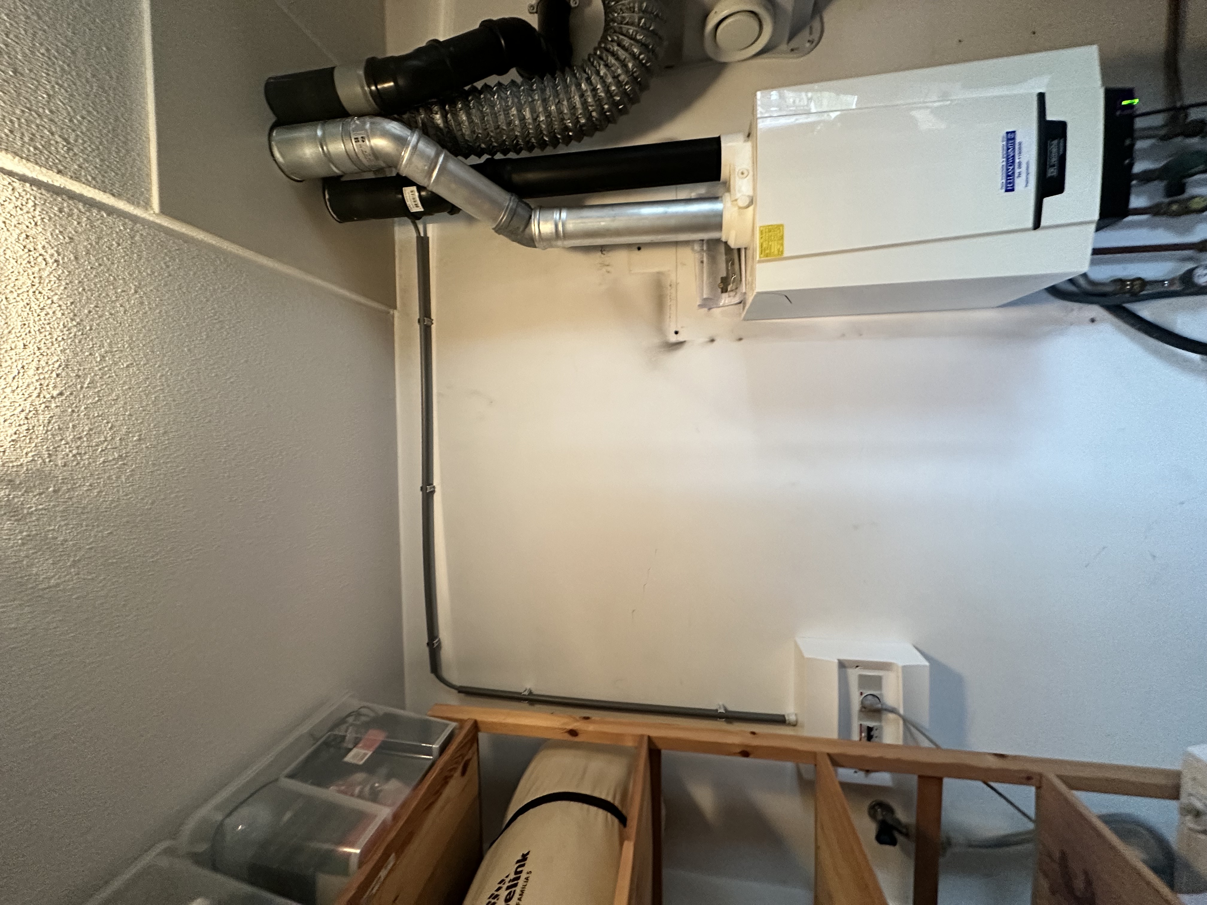 De foto toont een deel van een installatie met een omvormer die typisch is voor zonnepanelen.