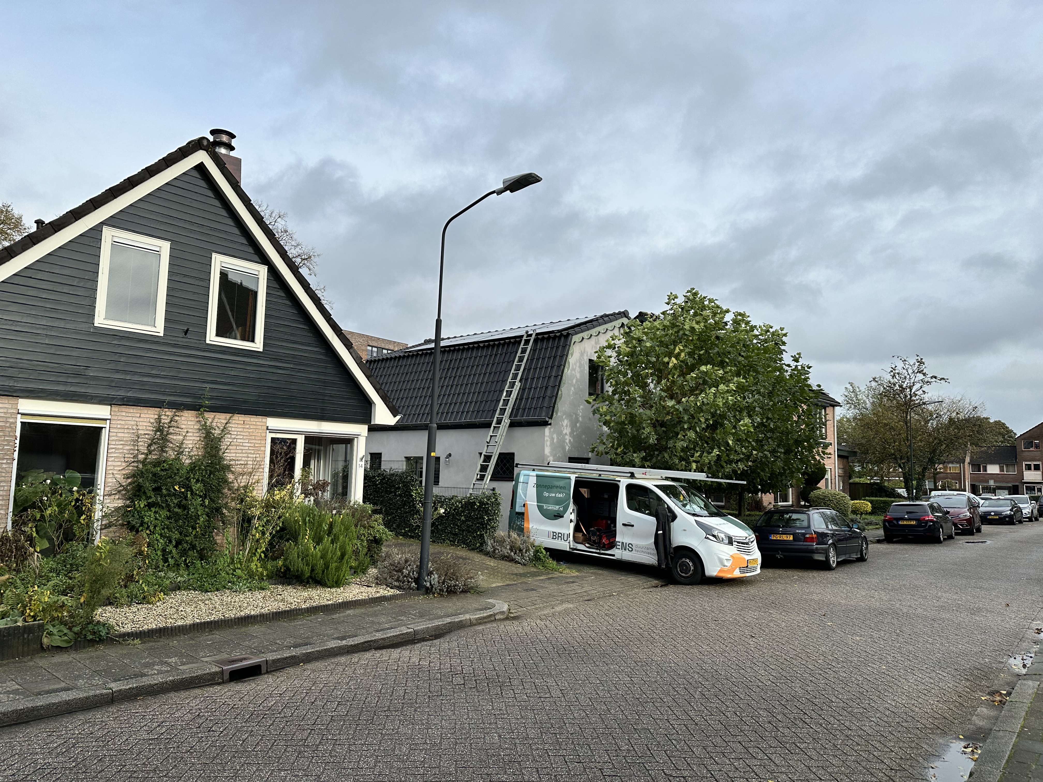 De foto toont een woning met een lopende installatie van zonnepanelen op het dak, met een vrachtwagen voor de werkzaamheden.