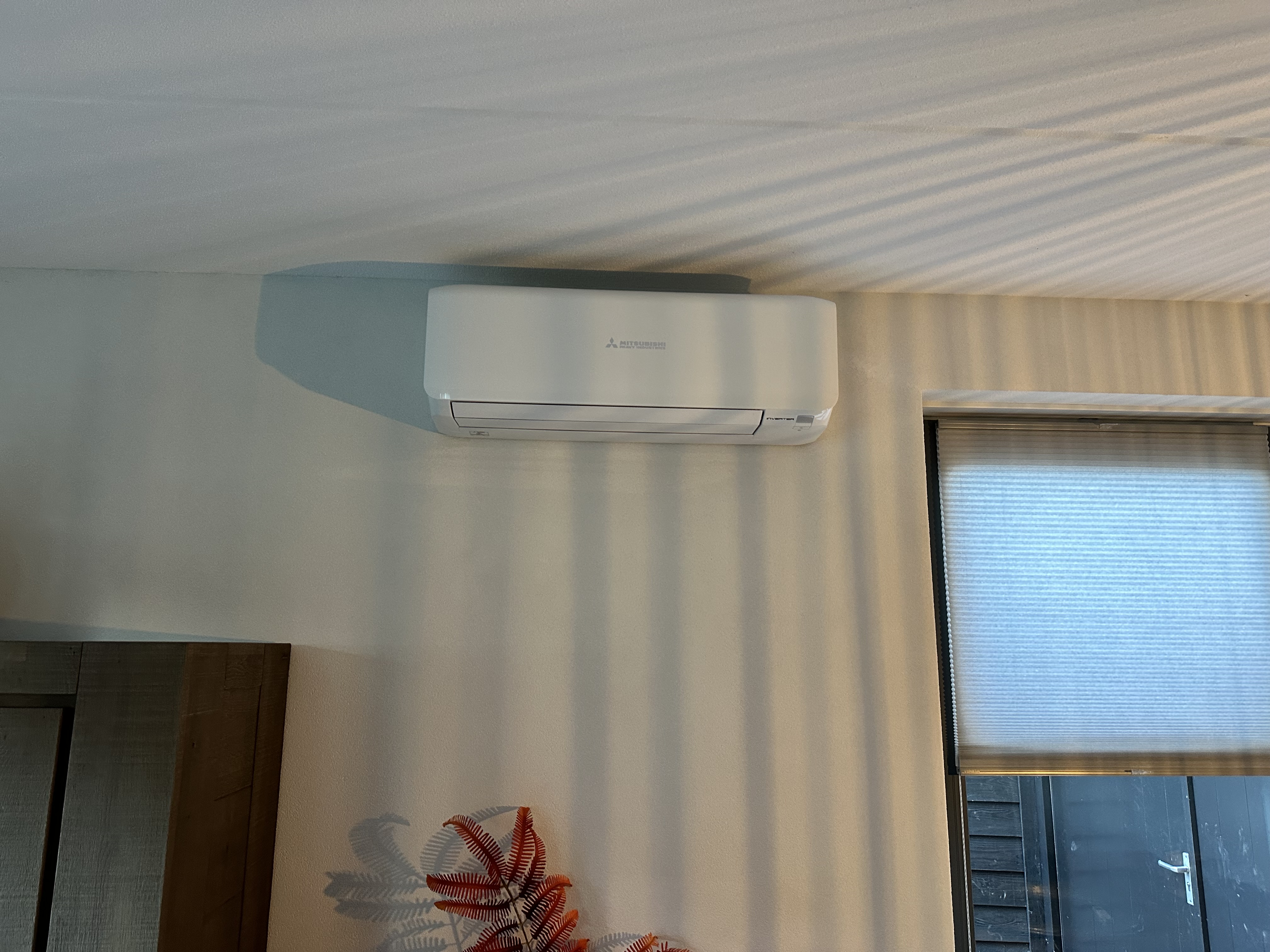 Een gemonteerde airconditioningseenheid aan de muur, ontworpen voor efficiënte koeling van de ruimte.