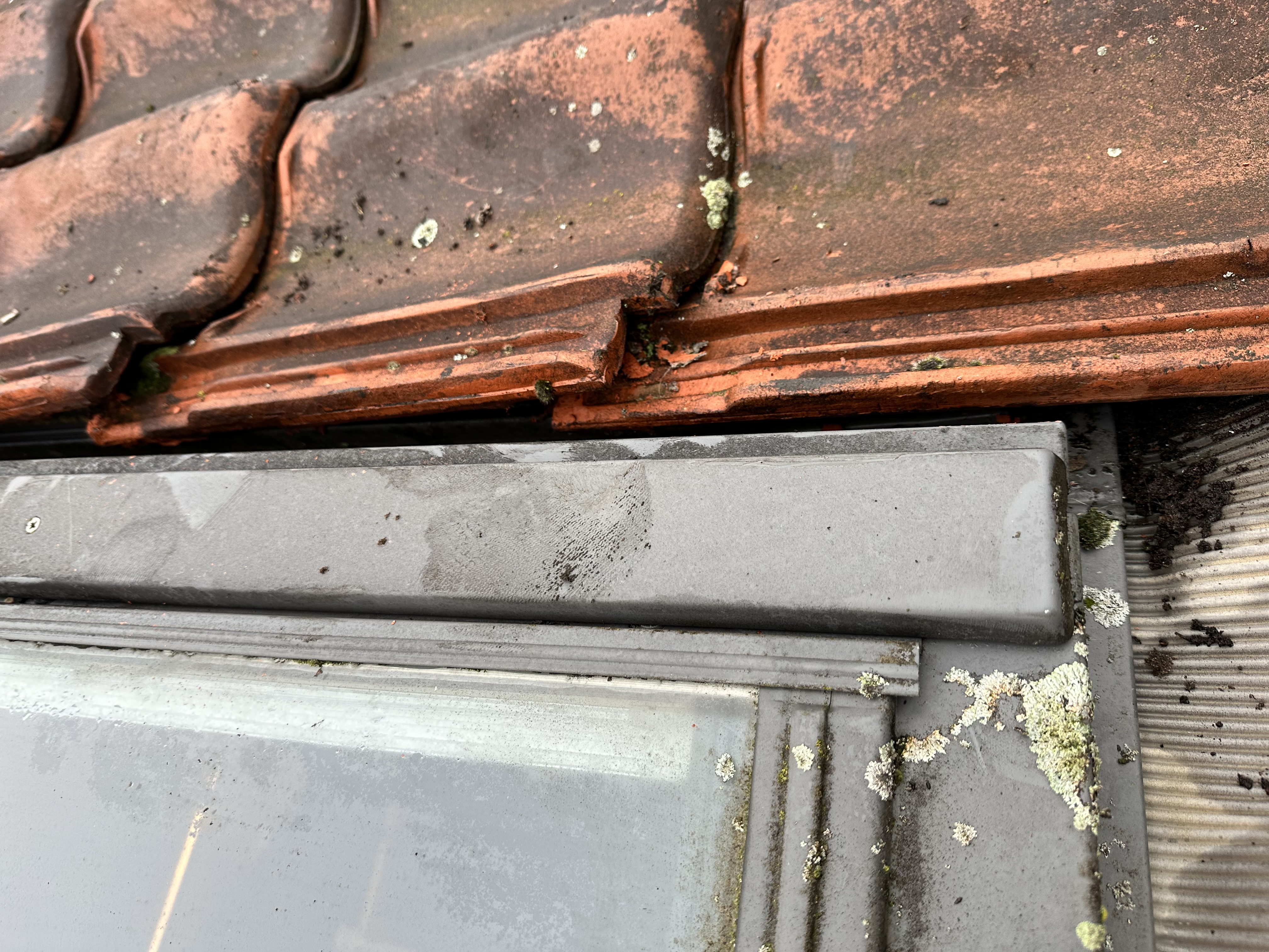 De installatie toont een integraal zonnepanelensysteem dat bovenop dakpannen geplaatst is, met zichtbare details van de aansluiting.