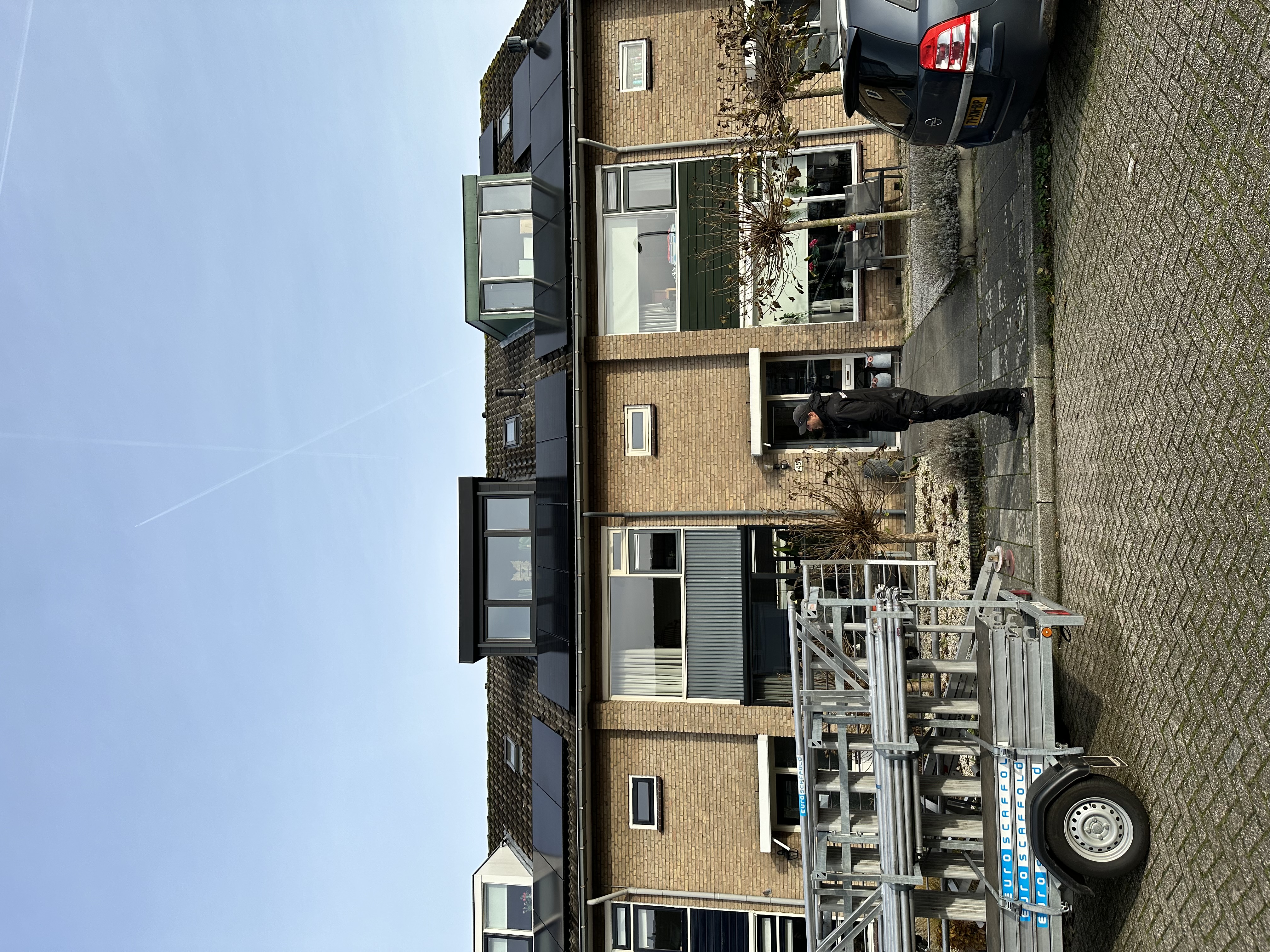 Een woning met zonnepanelen op het dak, zichtbaar vanaf de straat. De installatie is verzorgd en professioneel gepresenteerd.