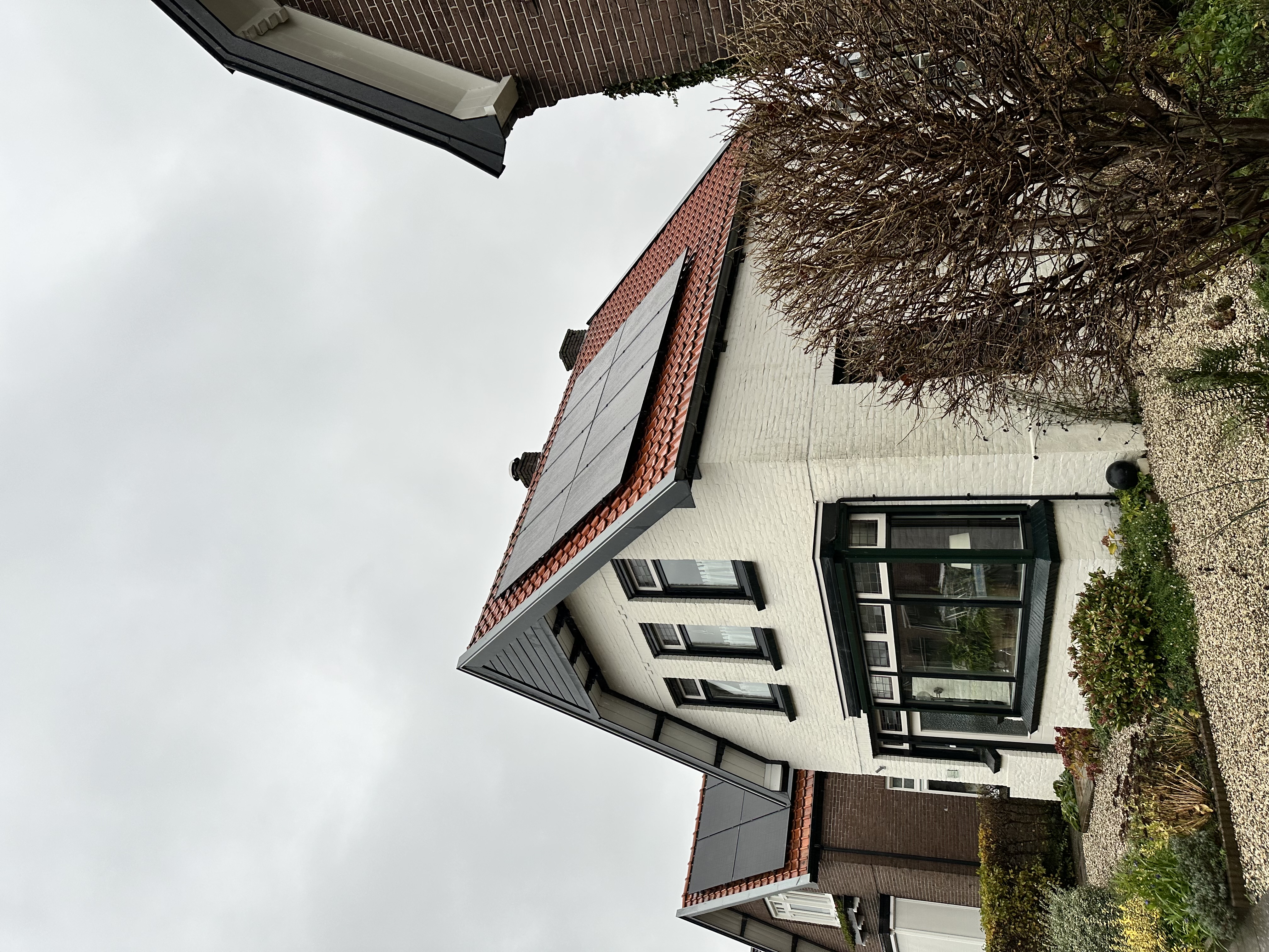 De foto toont een woning met zonnepanelen op het dak, ideaal voor zonne-energieproductie.