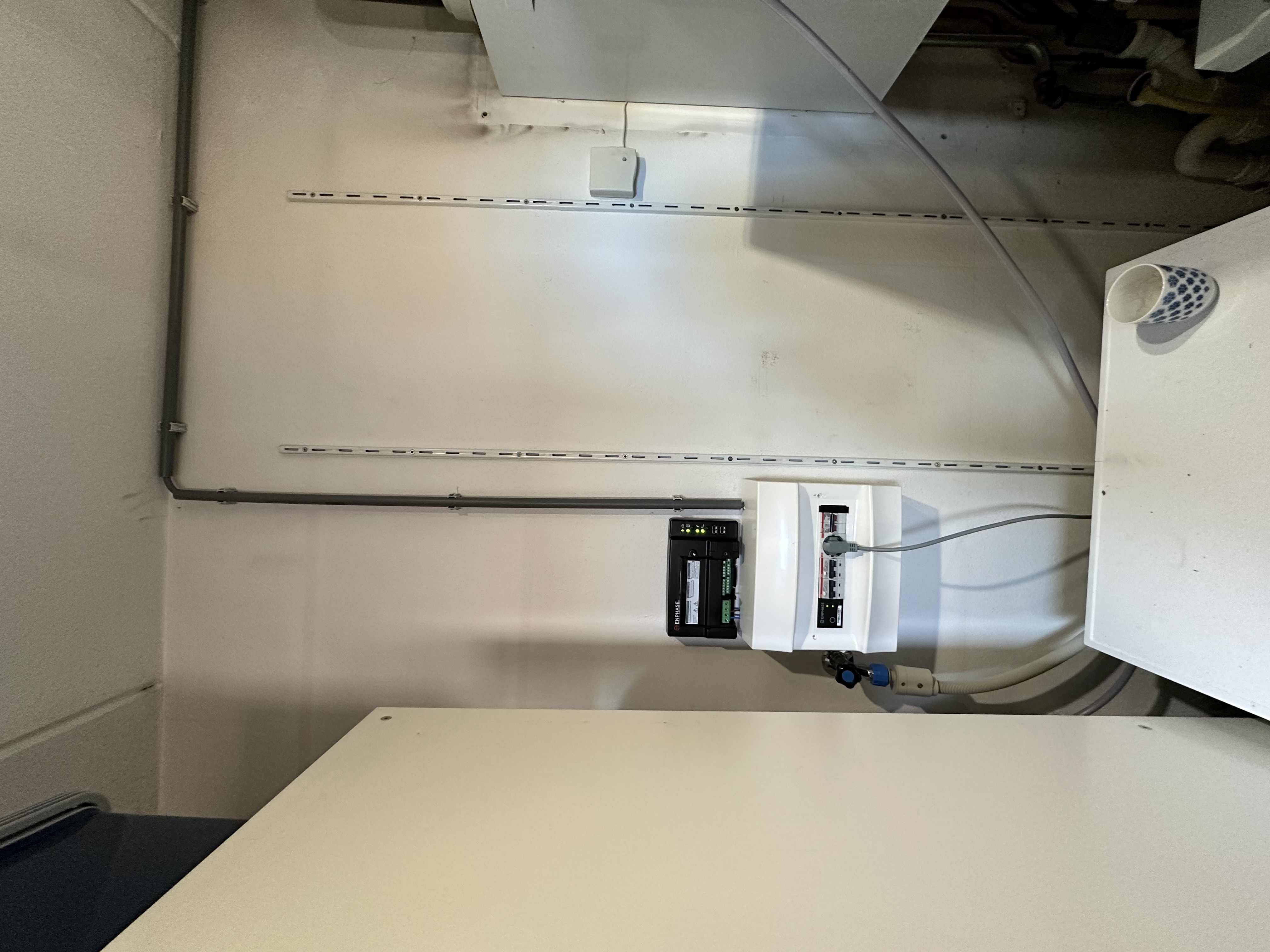 Het beeld toont een meterkast met de installatiecomponenten van een zonnepanelenproject.