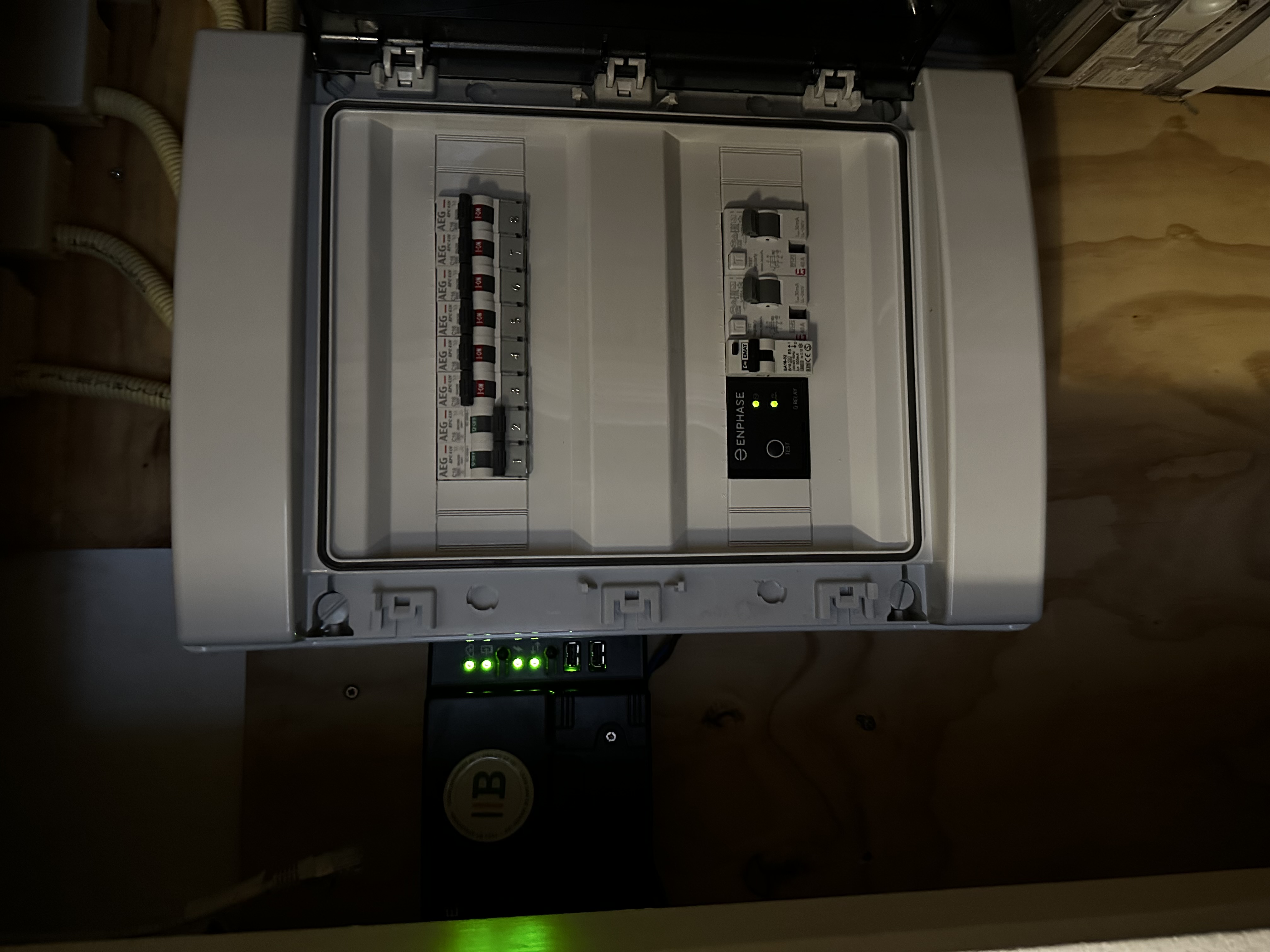 De afbeelding toont een meterkast met een Enphase omvormer, die verbinding maakt met de zonnepaneleninstallatie.