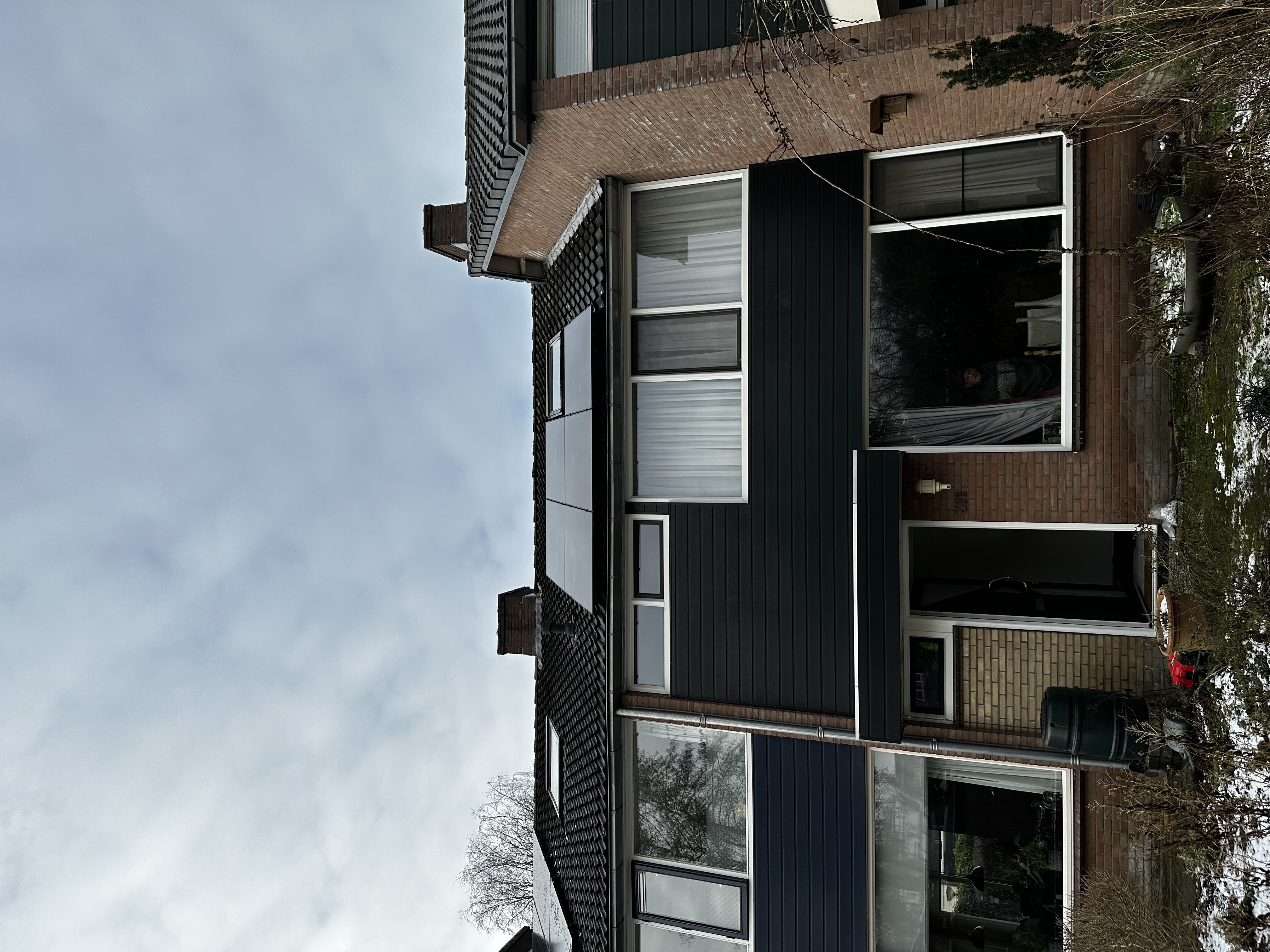 De foto toont een woning met zonnepanelen op het dak, wat aangeeft dat deze energietransitie is uitgevoerd.