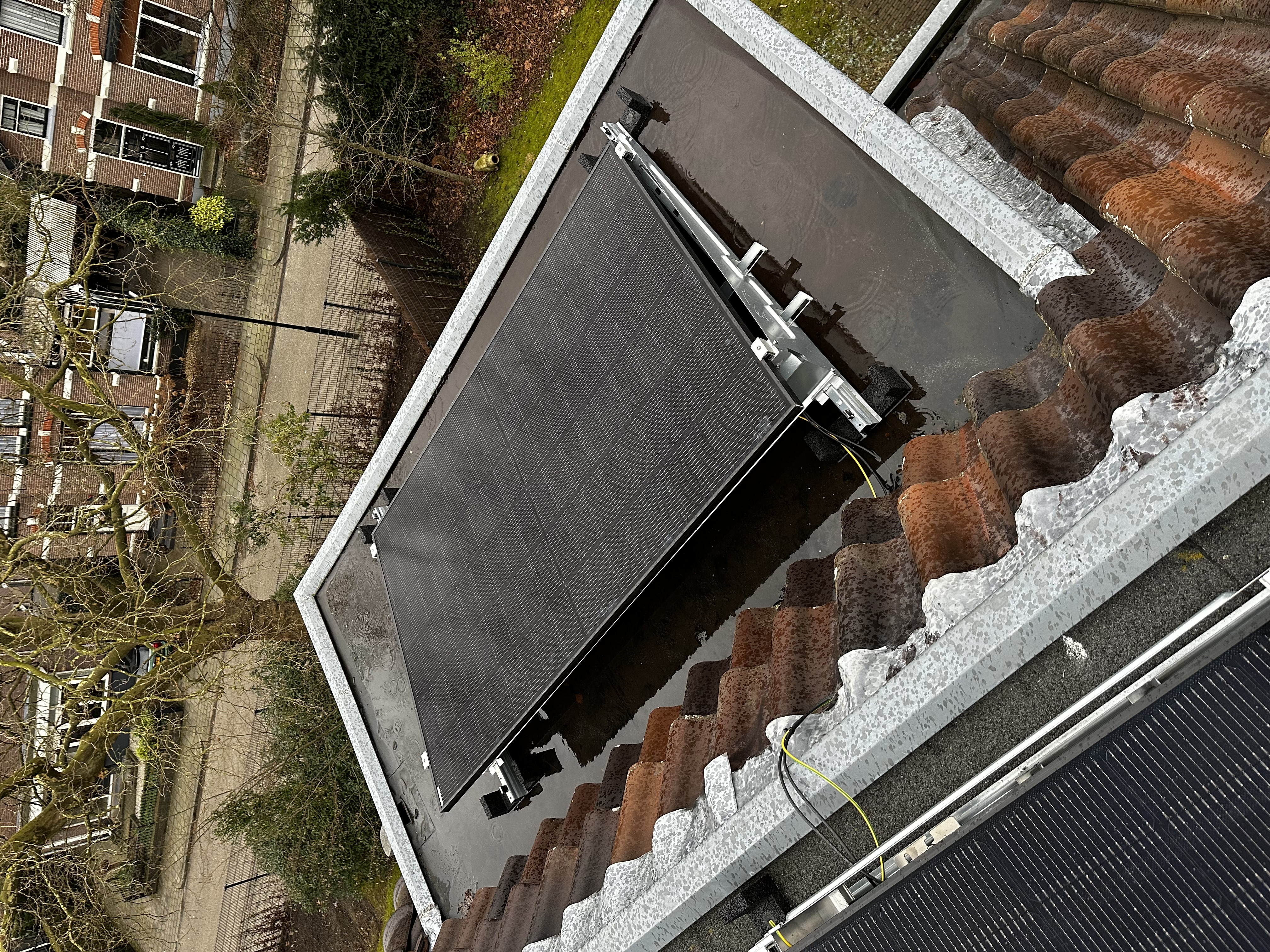 Een zonnepaneleninstallatie op een dak, met duidelijke zichtbaarheid van zonnepanelen en montagematerialen.
