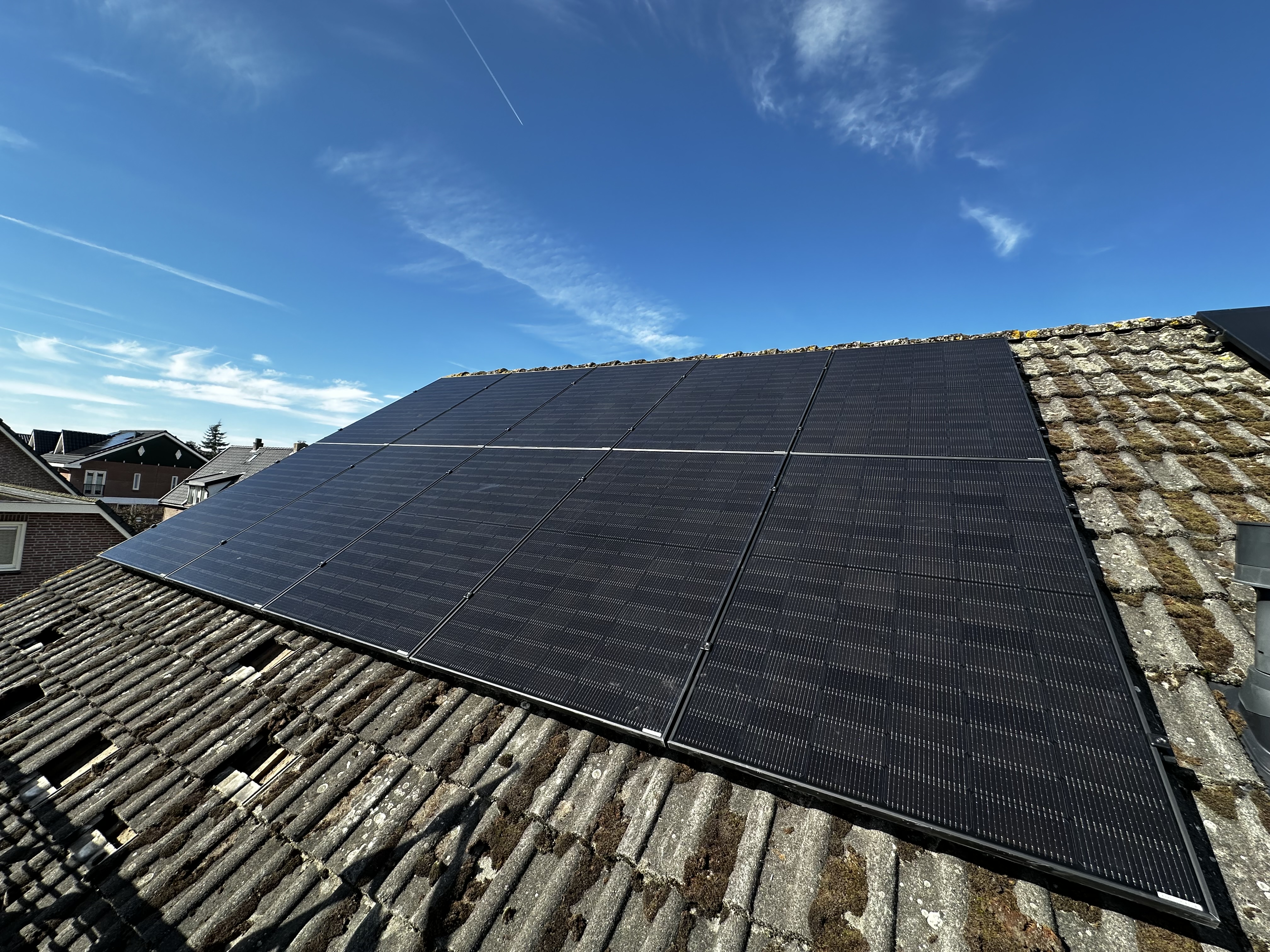 Deze installatie toont zonnepanelen op een hellend dak, duidelijk zichtbaar onder een heldere lucht.