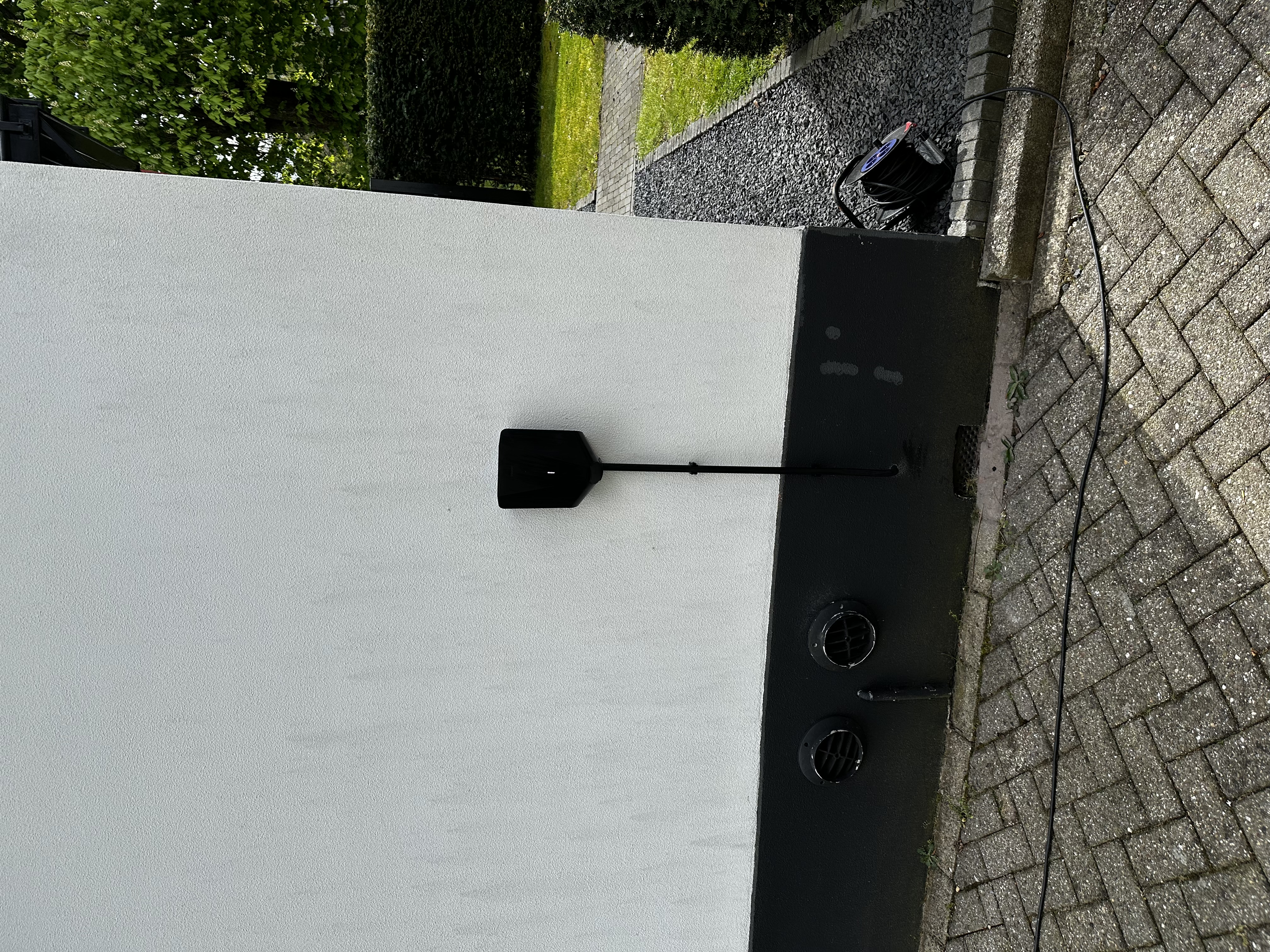 Een laadpaal is geïnstalleerd aan de muur van een woning, geschikt voor het opladen van elektrische voertuigen.