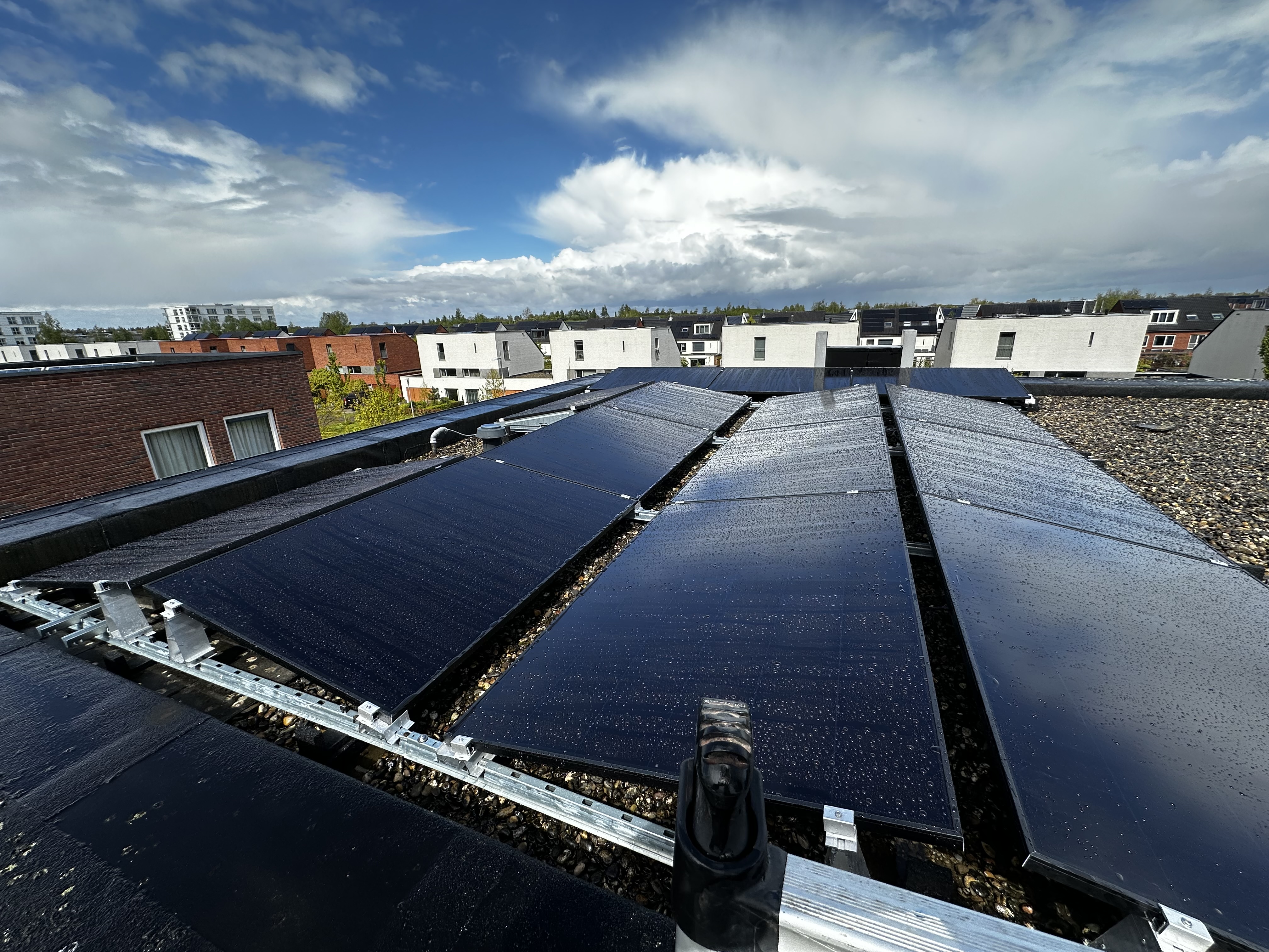 De installatie toont een reeks zonnepanelen op een vlakke dakbedekking, geschikt voor het opwekken van zonne-energie.
