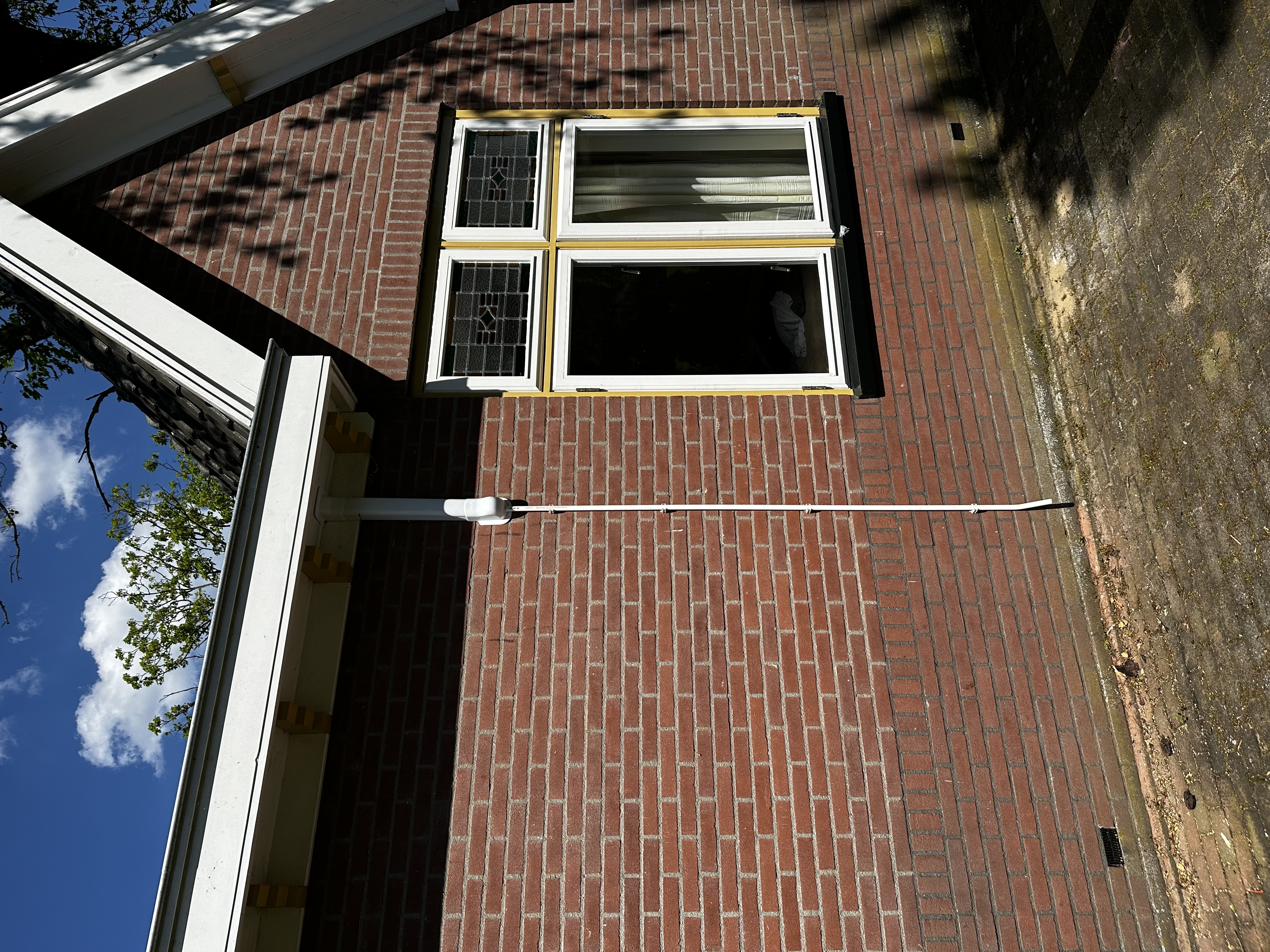 Een buitenunit van een airconditioning systeem geïnstalleerd aan de gevel van een huis.